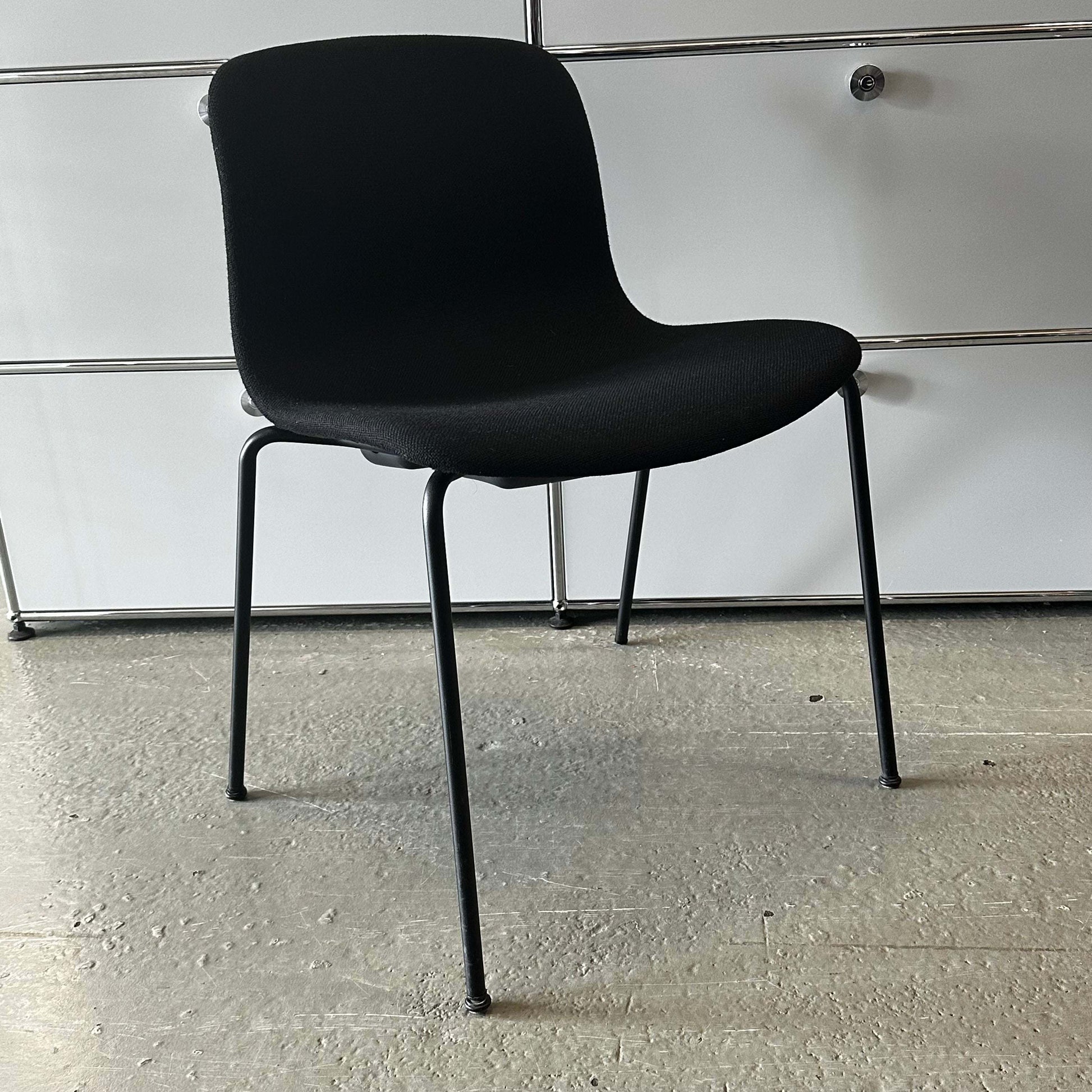 Modern black Hay Chair AAC 17 with sleek design and metal legs on concrete floor