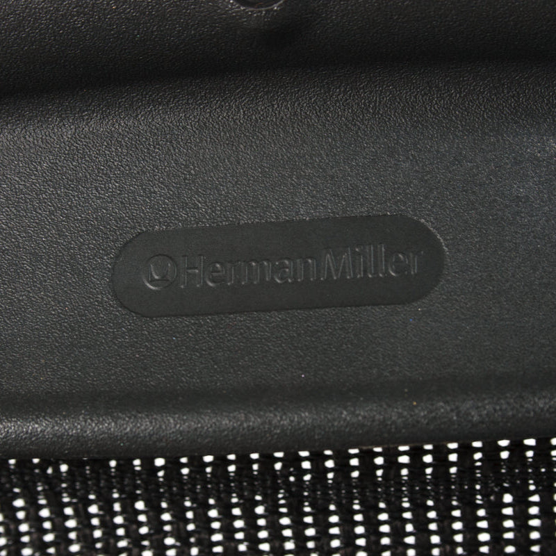 Herman Miller Aeron Bürostuhl Logo auf schwarzem Kunststoffrahmen mit Netzstoff.