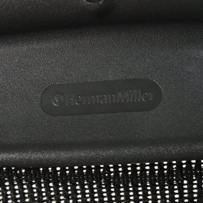 Herman Miller Aeron Bürostuhl Logo auf schwarzem Kunststoffrahmen mit Netzstoff.