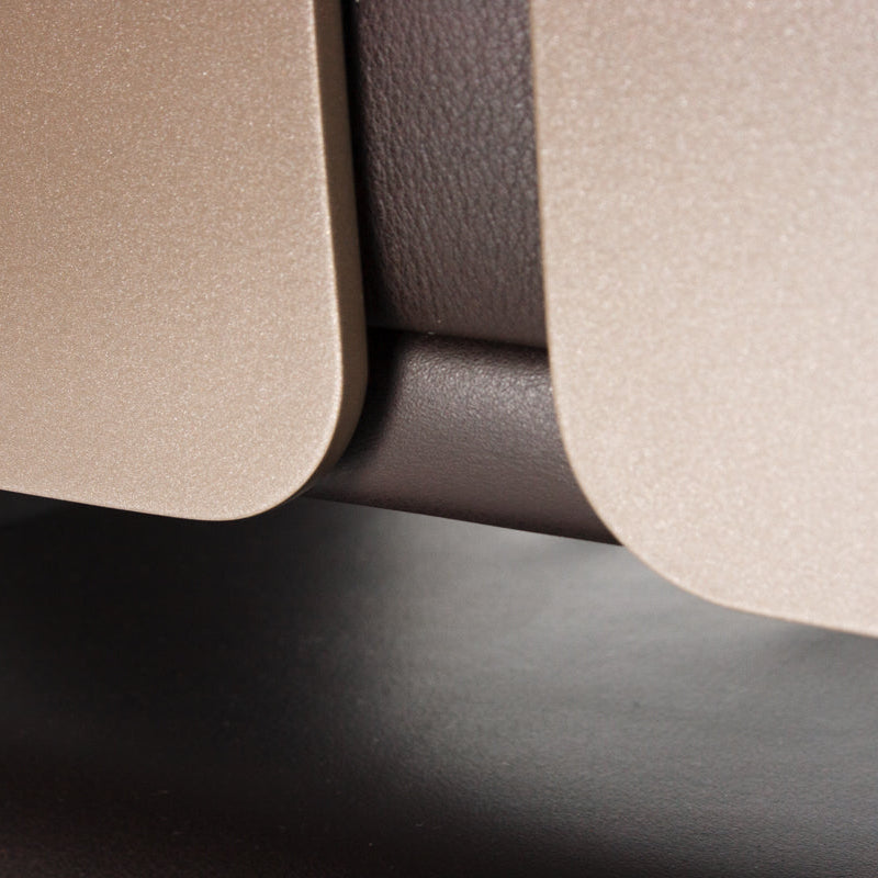 Detailaufnahme: Interstuhl Silver Bürostuhl mit dunkelbraunem Leder und beigem Aluminiumgestell.