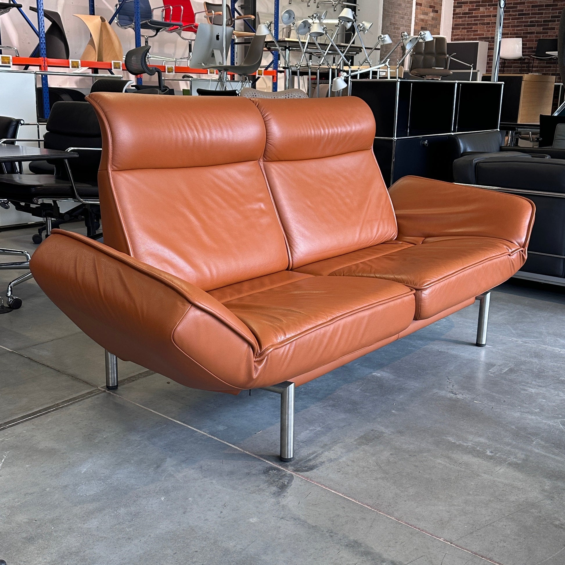 De Sede Drehsofa DS450 Twist aus nougatfarbenem Premium-Leder, drehbare Sitzelemente und kippbare Rückenlehnen.
