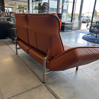 De Sede Drehsofa DS450 Twist aus nougatfarbenem Leder mit drehbaren Sitzelementen und kippbaren Rückenlehnen in modernem Showroom