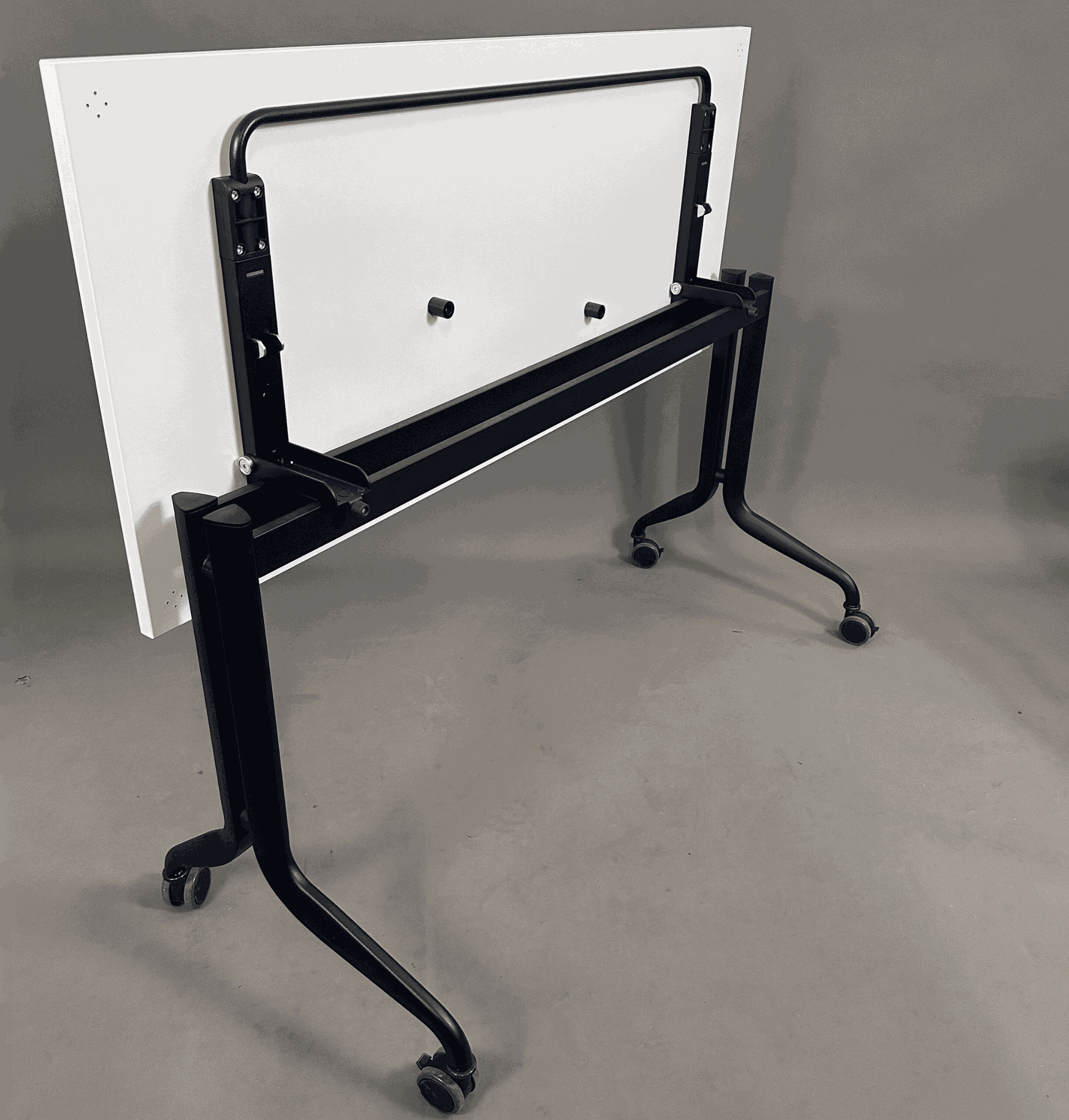 Interstuhl Klapptisch 140x60 cm mit schwarzem Metallgestell und Rollen, zusammengeklappt stehend