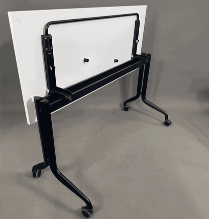 Interstuhl Klapptisch 140x60 cm mit schwarzem Metallgestell und Rollen, zusammengeklappt stehend
