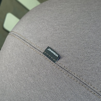 Johanson Atticus low Loungesessel mit grauem Stoffbezug und schwarzem Johanson-Label.