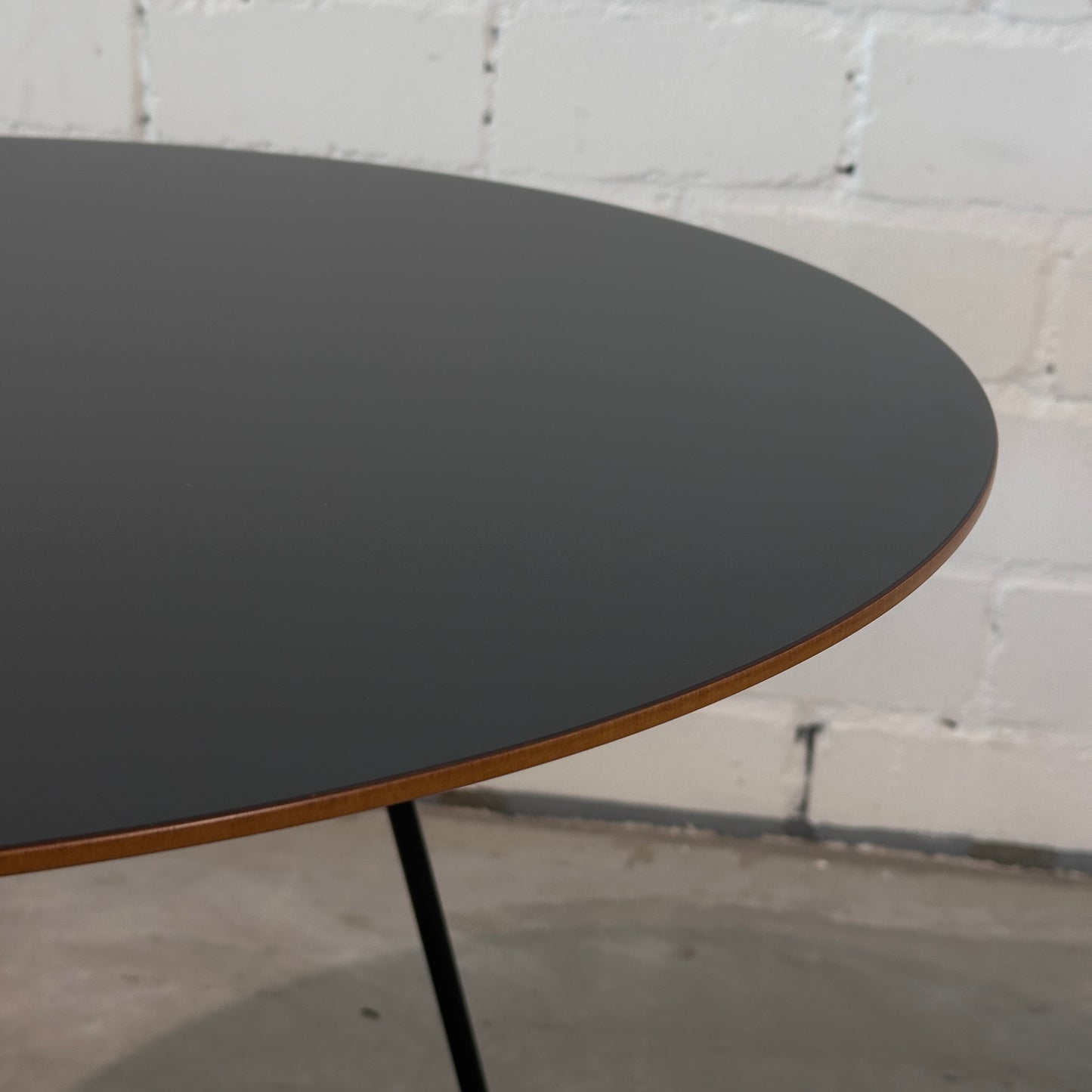 Johanson Speed Table Beistelltisch, runde schwarze Schichtholzplatte mit braunem Rand und schwarzen Beinen.
