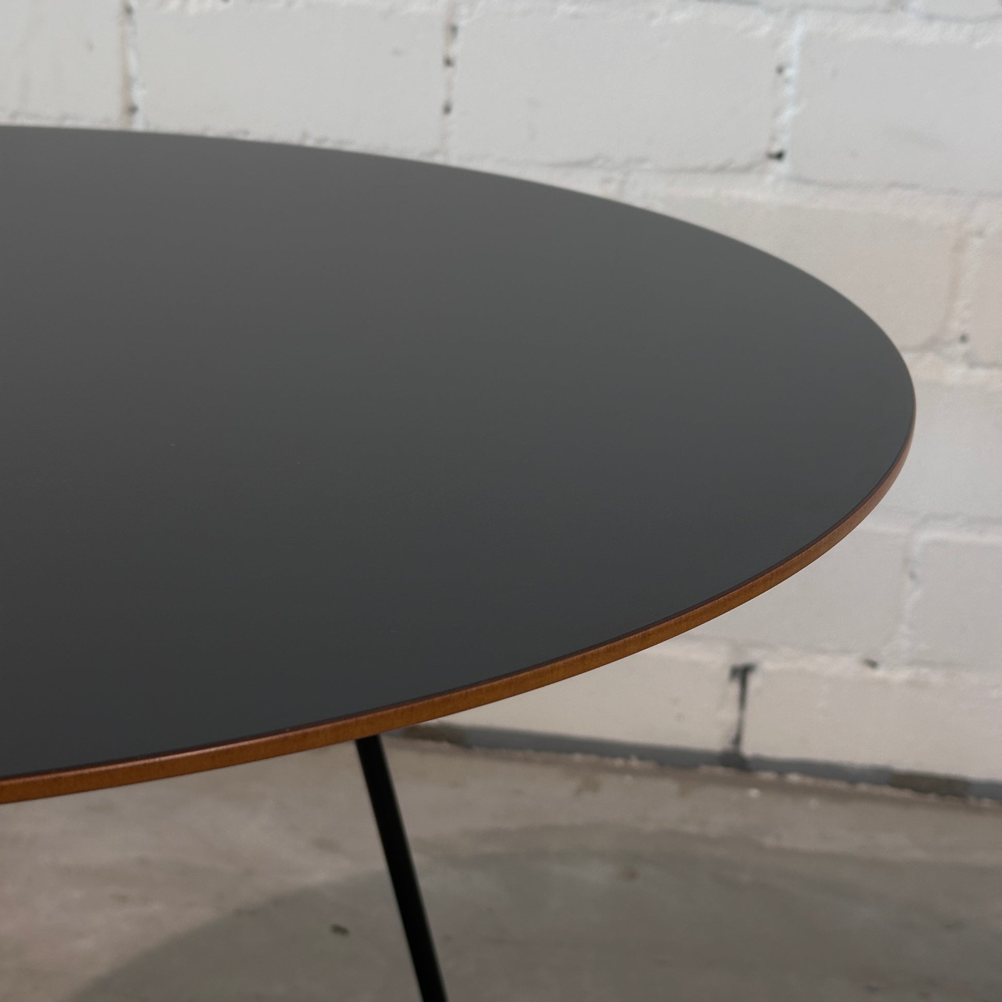 Johanson Speed Table Beistelltisch, runde schwarze Schichtholzplatte mit braunem Rand und schwarzen Beinen.