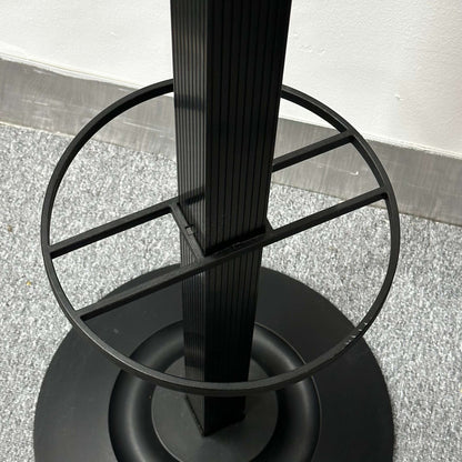 Close-up of the black Kartell Segmenti Garderobenständer base and ring detail on a carpeted floor