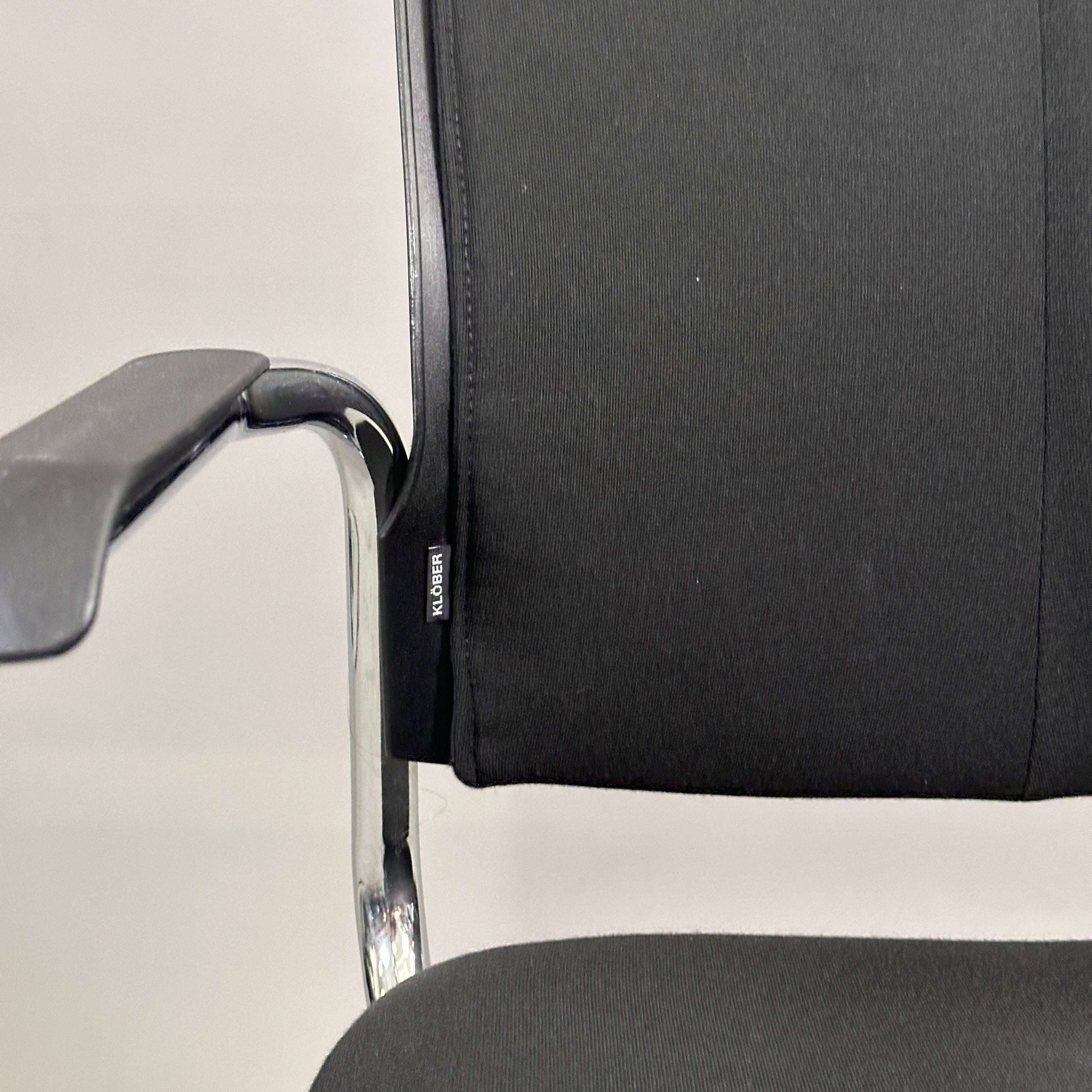Black upholstered Klöber Besprechungsstuhl meeting chair with chrome frame and armrest, stackable design