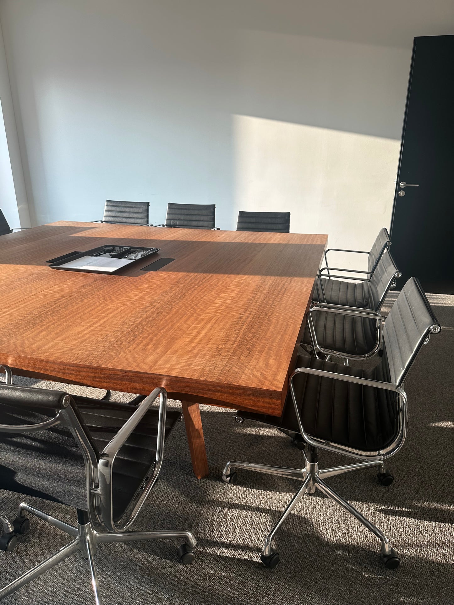 Großer quadratischer Konferenztisch aus Holz (240x240cm) mit 9 schwarzen Bürostühlen und Elektrifizierung.