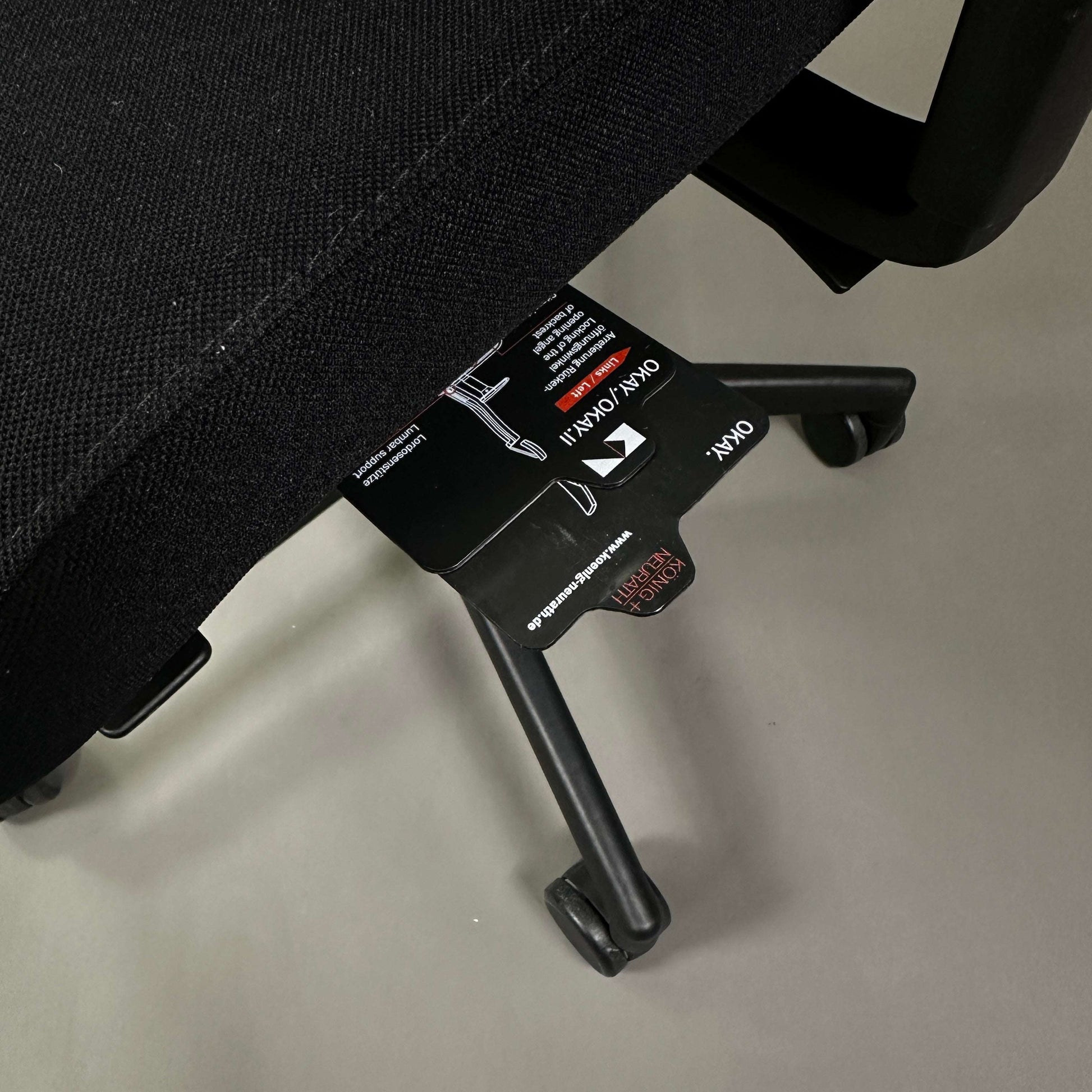 Close-up of König & Neurath Okay2 office chair base and adjustment labels