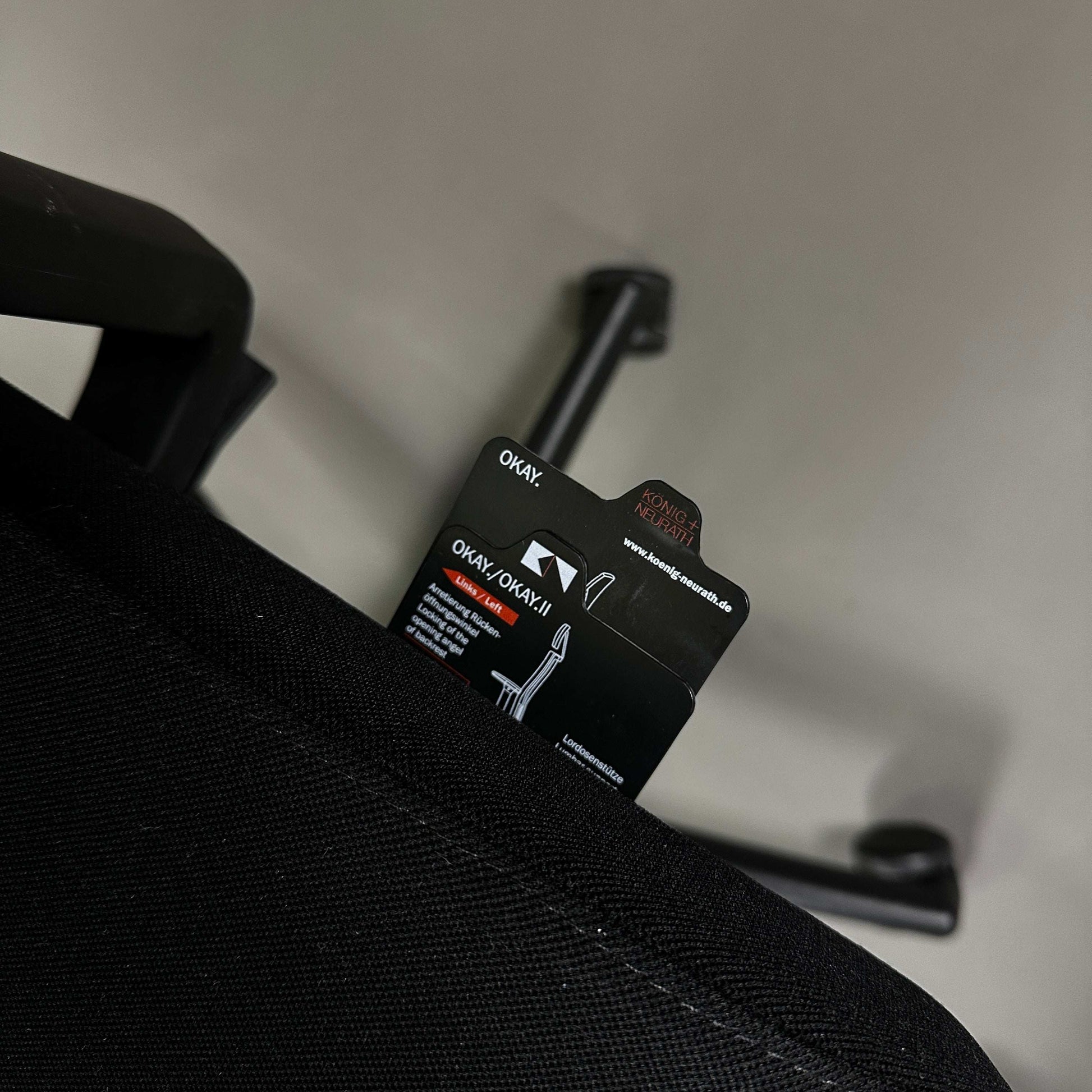 Close-up of König & Neurath Okay2 office chair backrest tag and armrest