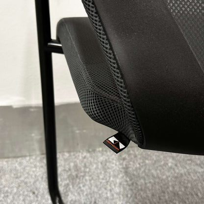 Close-up of König+Neurath Konferenzstuhl ergonomic conference chair seat with black mesh fabric and modern design.