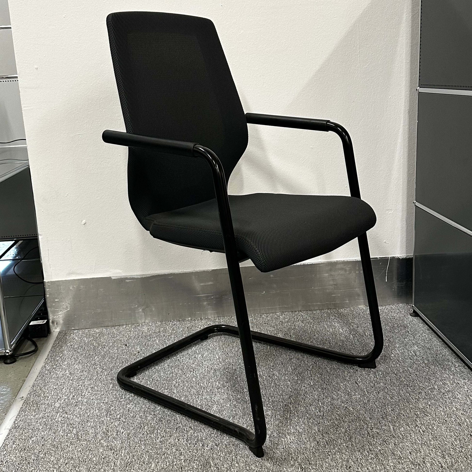 Black König+Neurath conference chair with ergonomic design and sleek metal frame in modern office setting