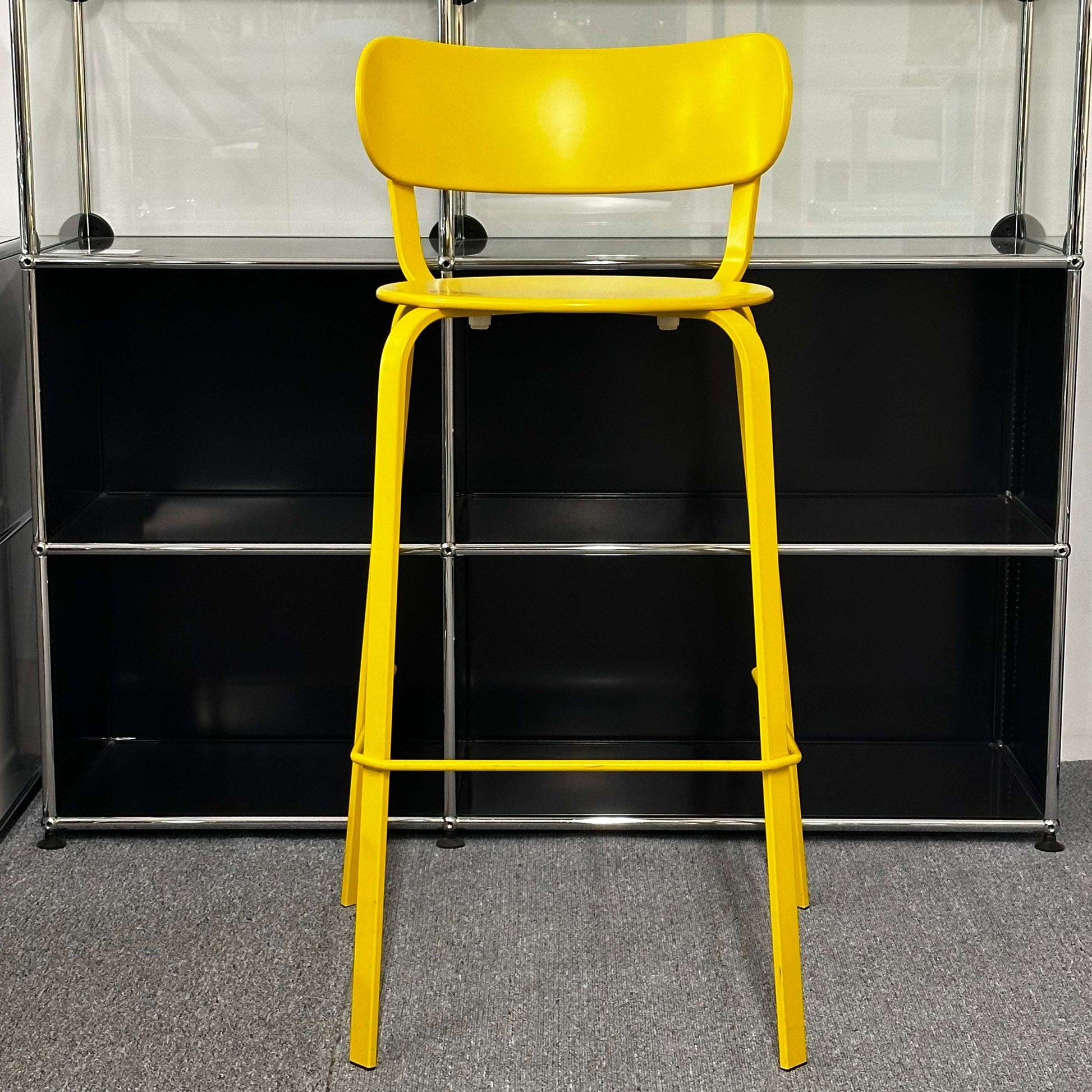 LaPalma Barhocker STIL S49 yellow bar stool with backrest in front of black shelving unit