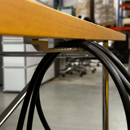 Close-up of Lampert Eiermann Tisch with chrome side-crossed frame and wooden tabletop in office setting