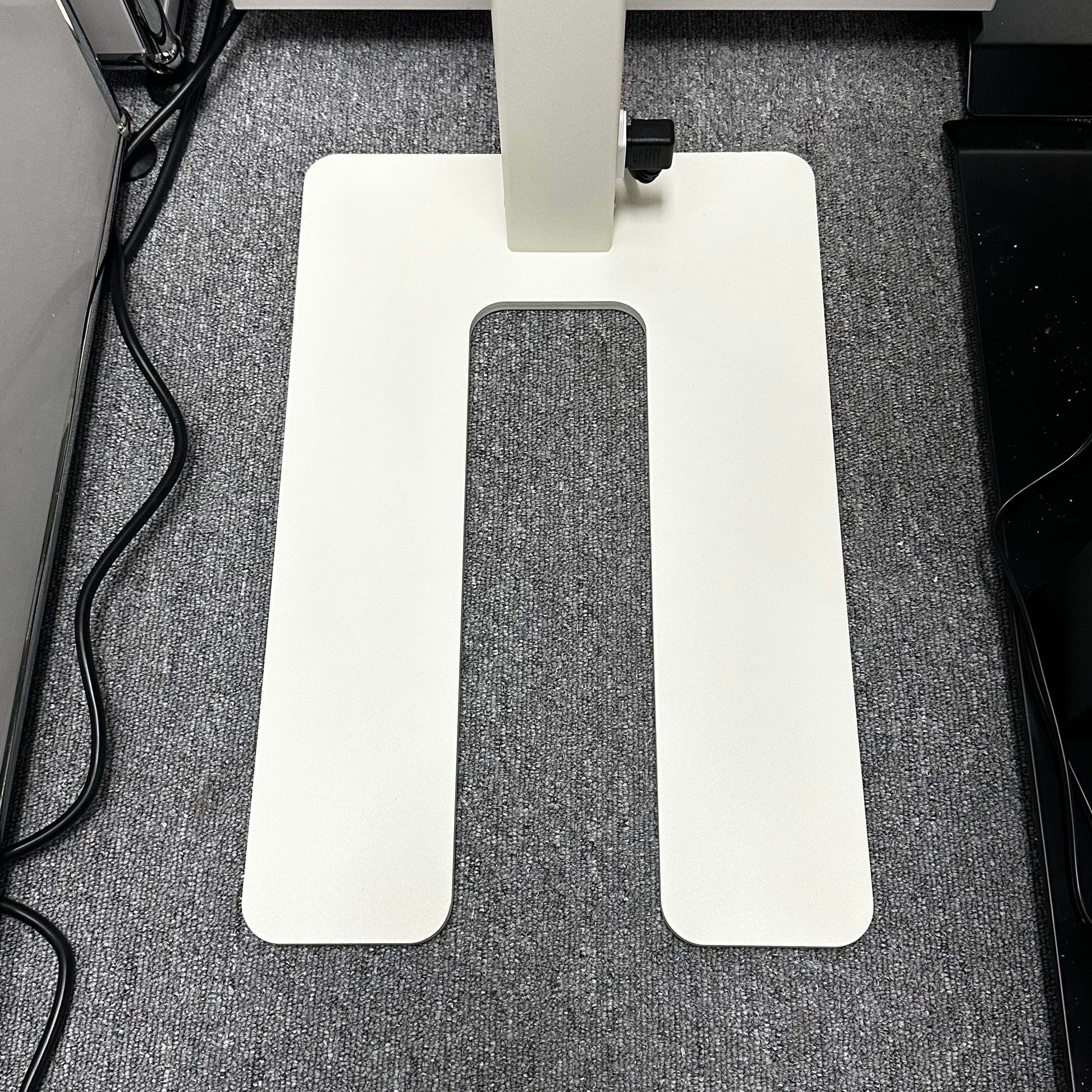 White rectangular base of Lenorad LED Stehlampe floor lamp on gray carpet with power cords nearby
