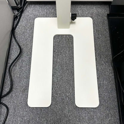 White rectangular base of Lenorad LED Stehlampe floor lamp on gray carpet with power cords nearby
