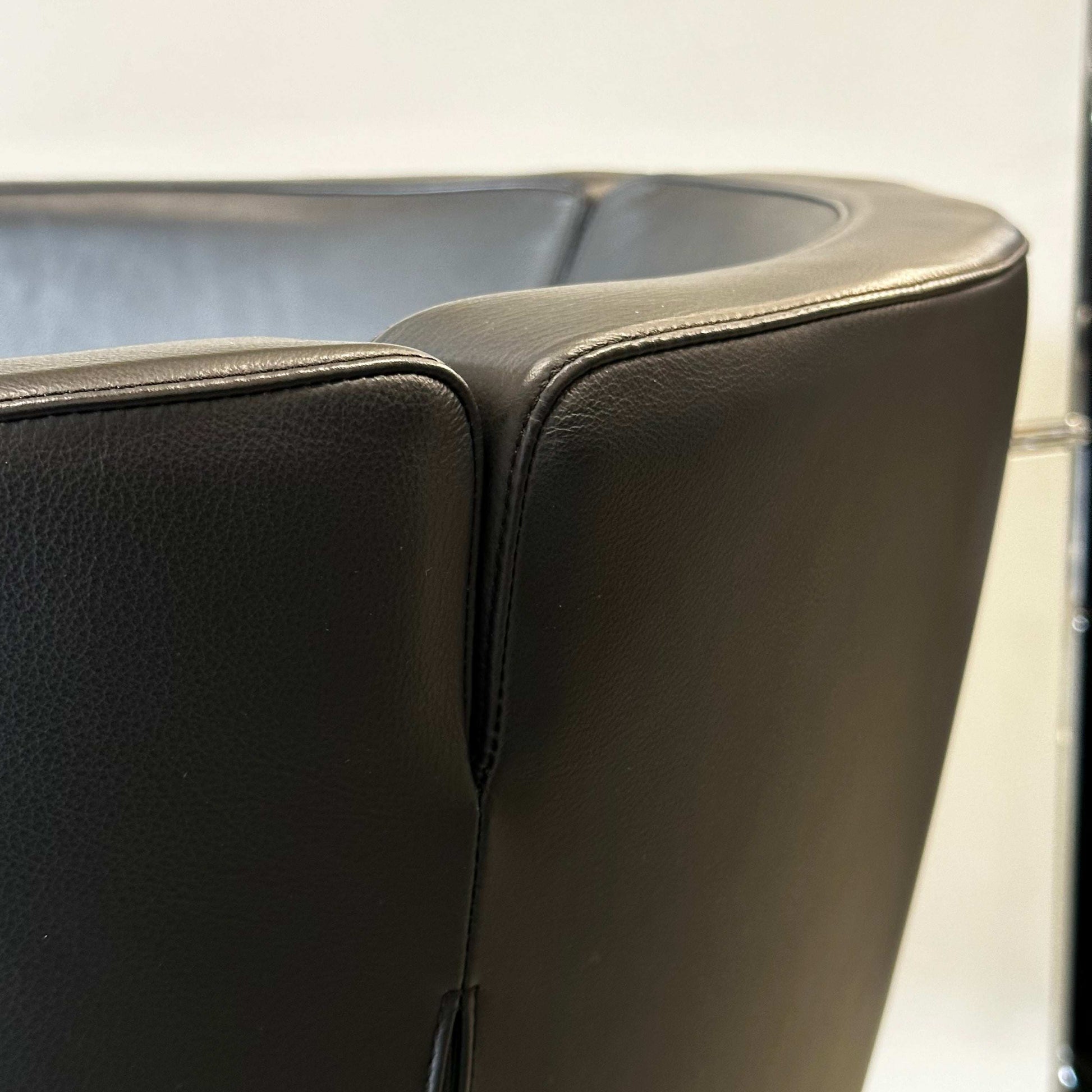 Close-up of black Living Divani Jelly leather armchair showcasing smooth upholstery and modern design details