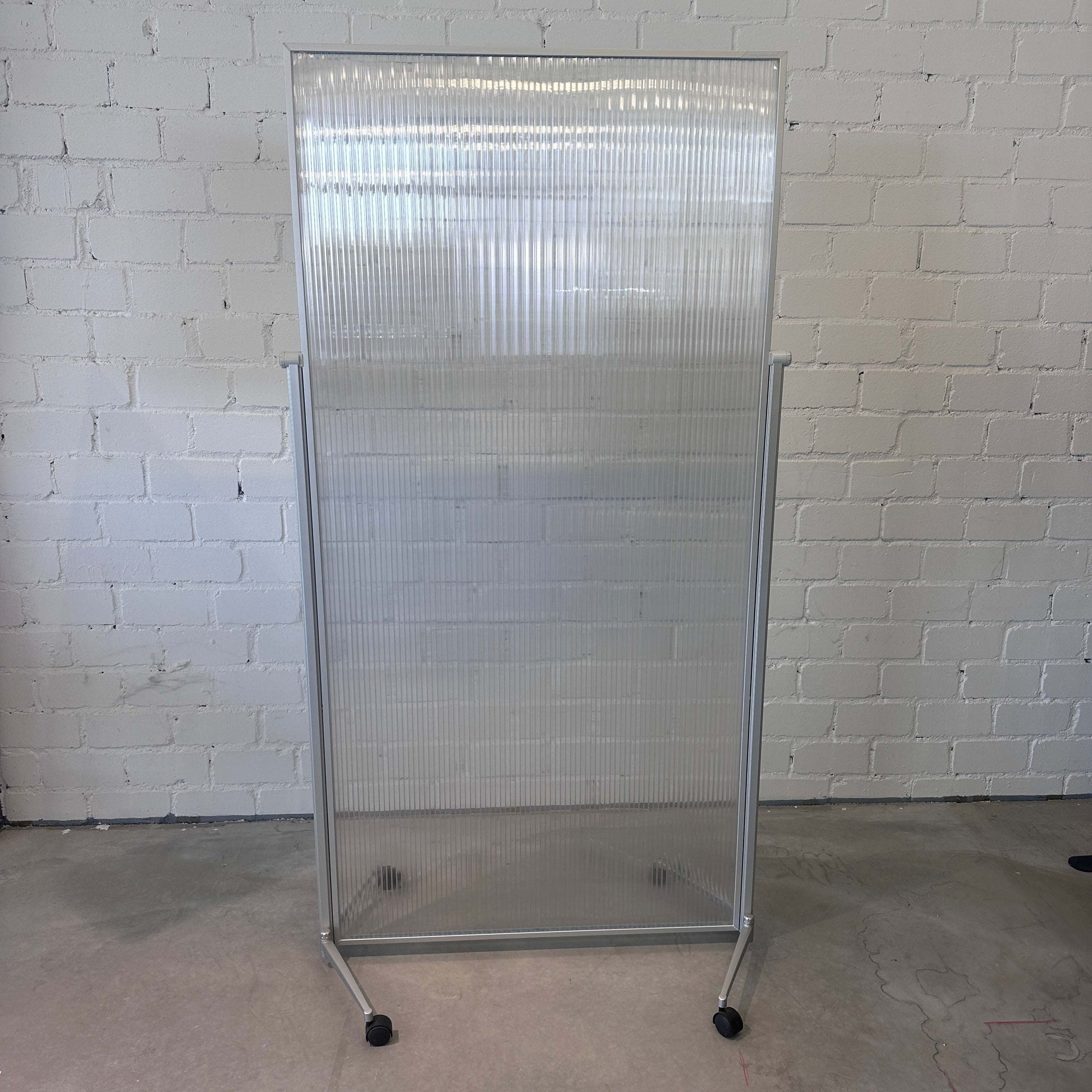 Magentoplan Raumteiler mobil matt transparent mit Maßen 100 x 207 cm auf Rollen vor weißer Backsteinwand