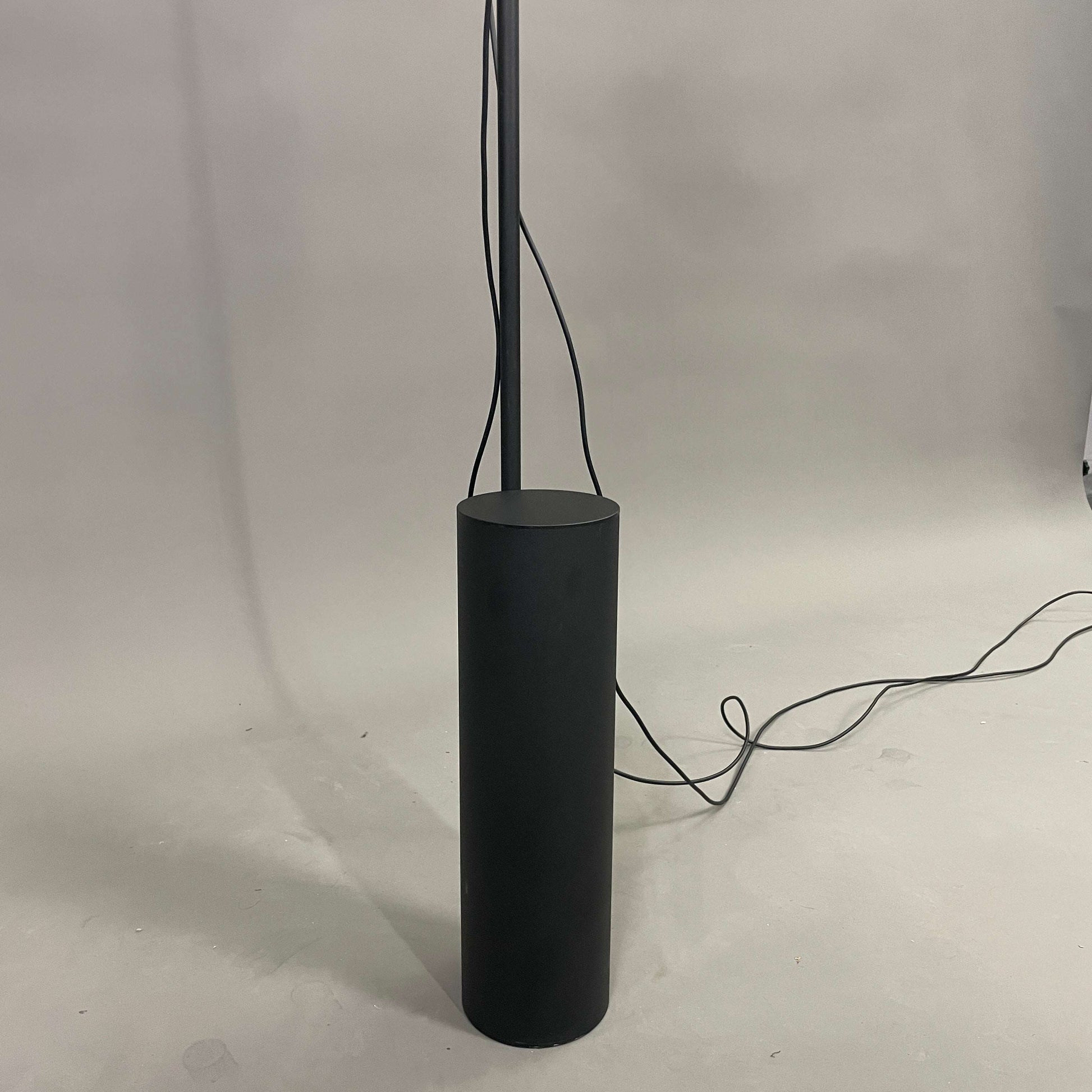 Schwarze Muuto POST Stehlampe mit magnetischem Leuchtmittel und zylindrischem Sockel.