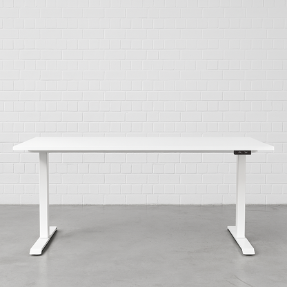 Elektrisch höhenverstellbarer Schreibtisch in Weiß, 140x80 cm, mit weißem Gestell und Bedienfeld vor weißer Ziegelwand.