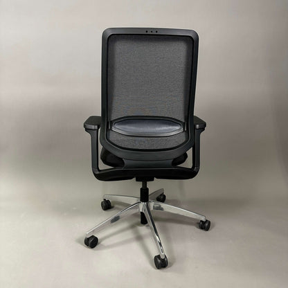 Back view of black SEDUS se:flex ergonomic office chair with mesh back, adjustable armrests, and swivel base with rubberized hard floor casters