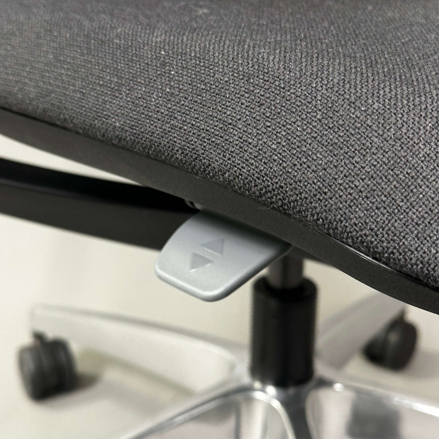 Close-up of SEDUS se:flex ergonomic office chair seat with height adjustment lever and caster wheels