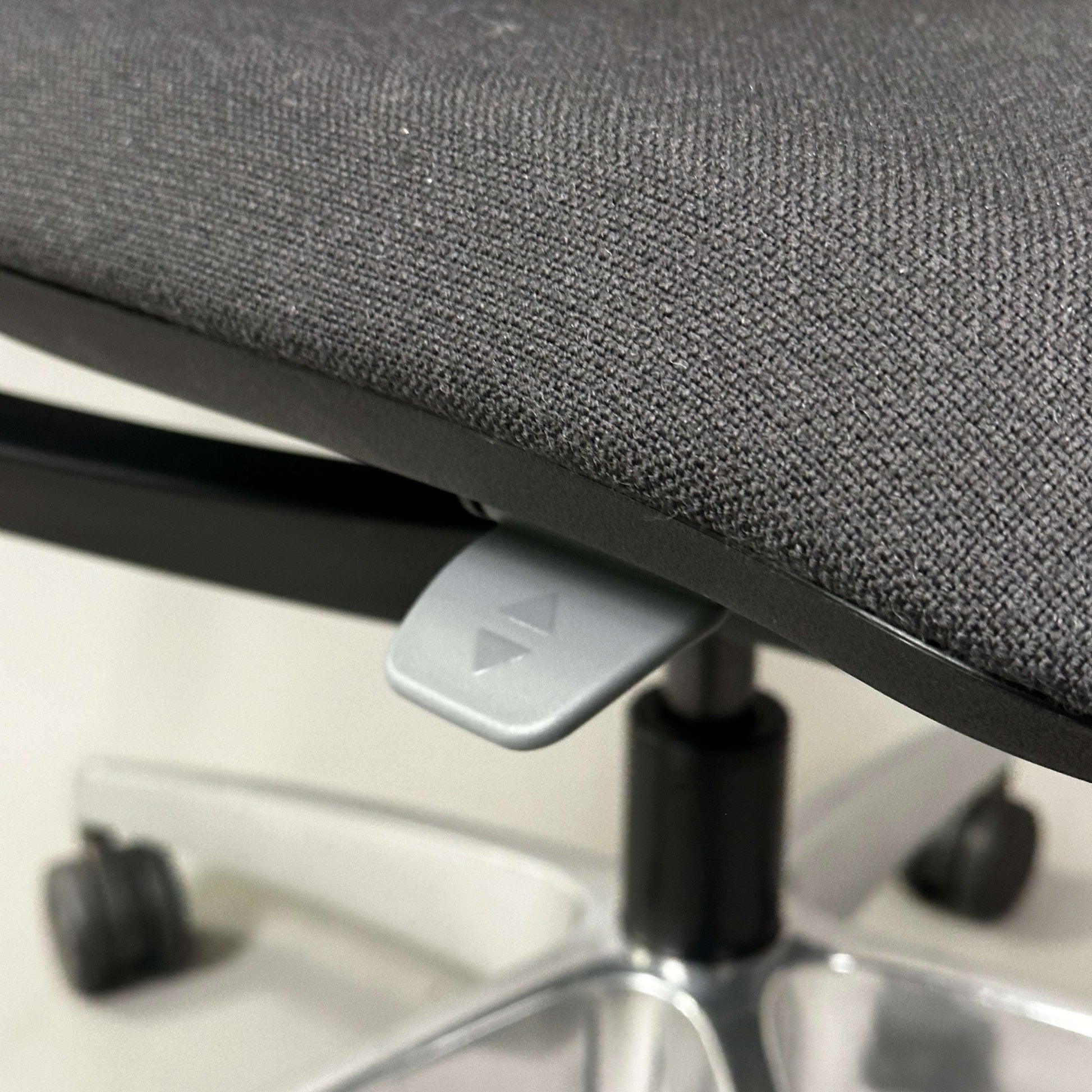 Close-up of SEDUS se:flex ergonomic office chair seat with height adjustment lever and caster wheels