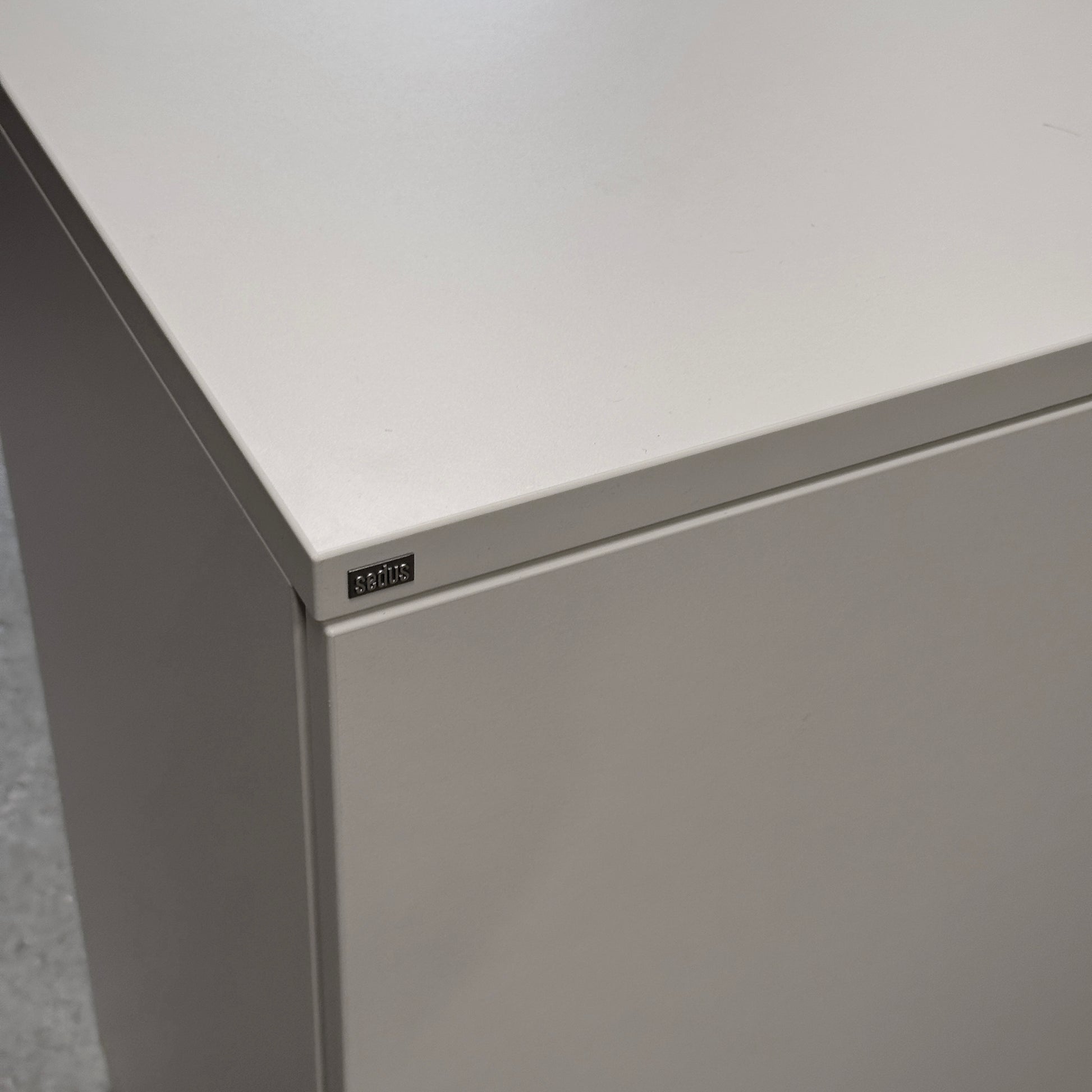 Weißer Sedus Flügeltürenschrank 2OH, abschließbar, mit dezenter Sedus-Plakette.