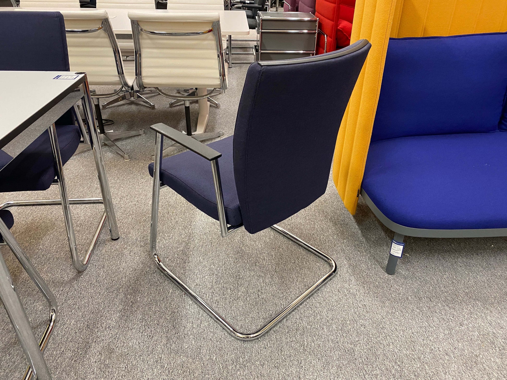 Sedus Freischwinger office chair with navy fabric seat and chrome cantilever frame in modern workspace setting