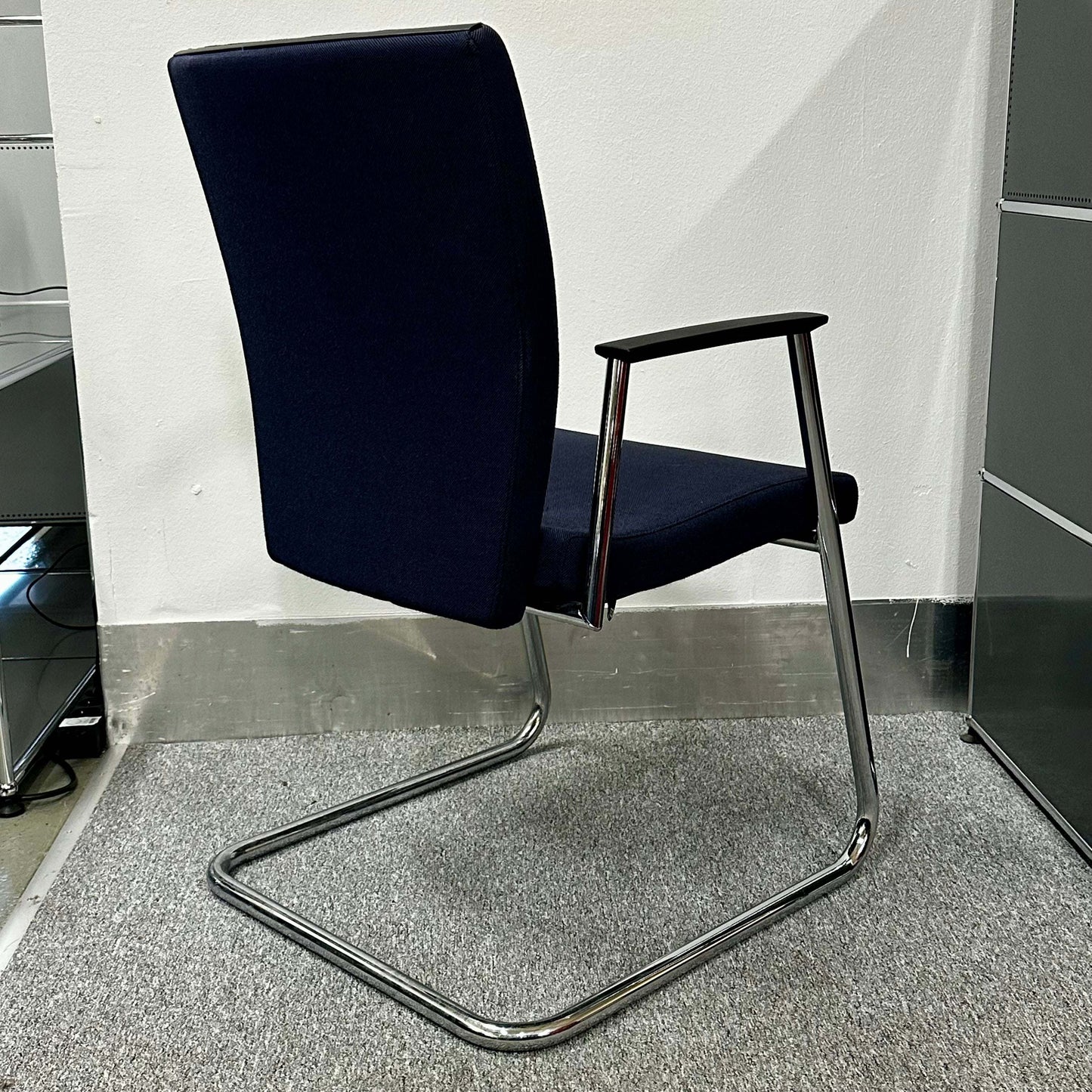 Sedus Freischwinger chair with ergonomic design, black seat and chrome cantilever frame.