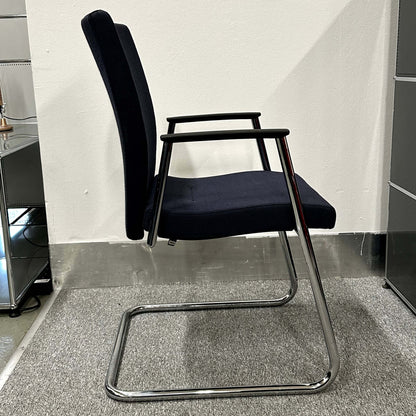 Side view of a Sedus Freischwinger chair with a black cushioned seat and backrest, featuring a chrome cantilever frame and armrests.