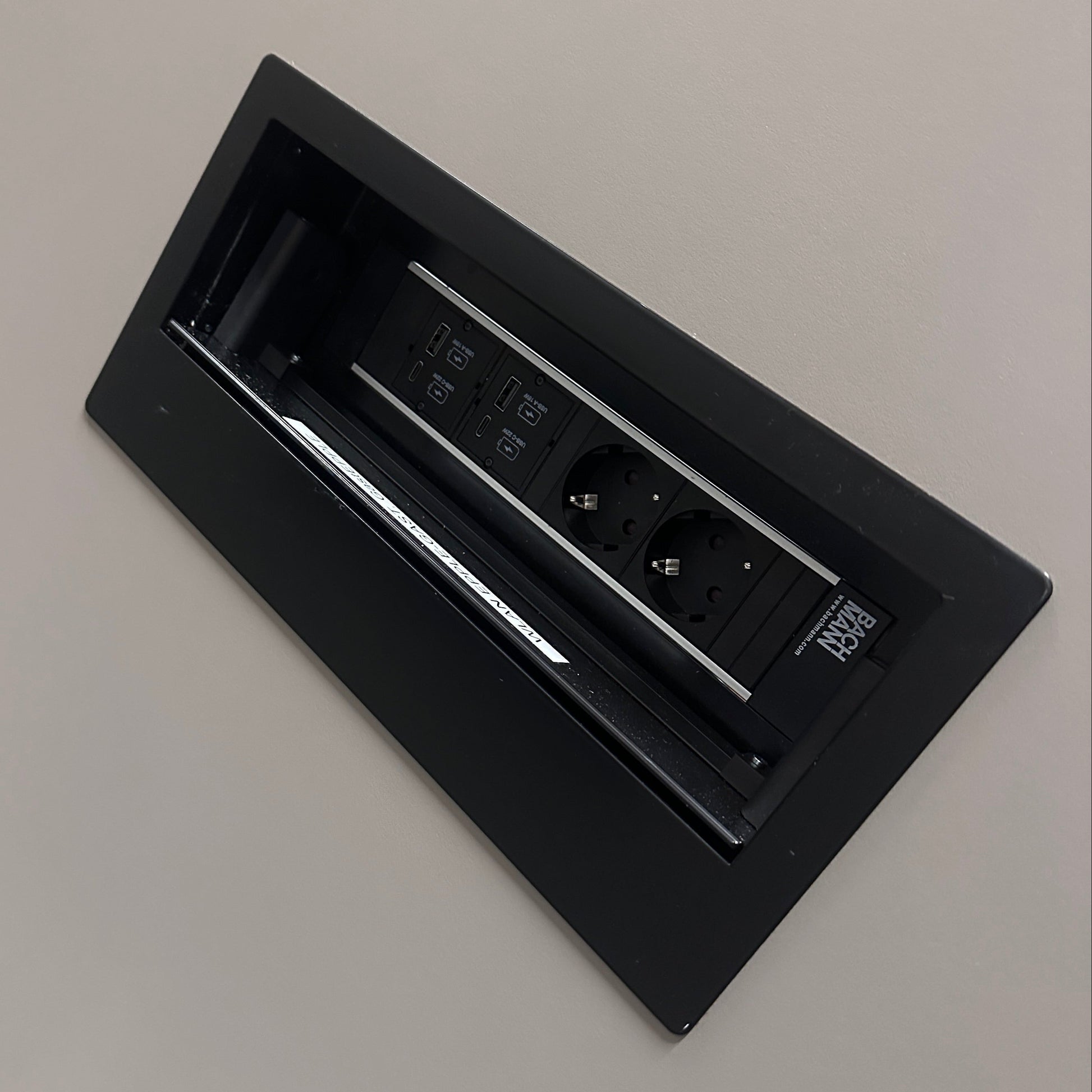 Bachmann Mediakit mit 2 Schuko, 2 USB, 2 USB-C Steckdosen, eingelassen in warmgrauem Sedus Konferenztisch.