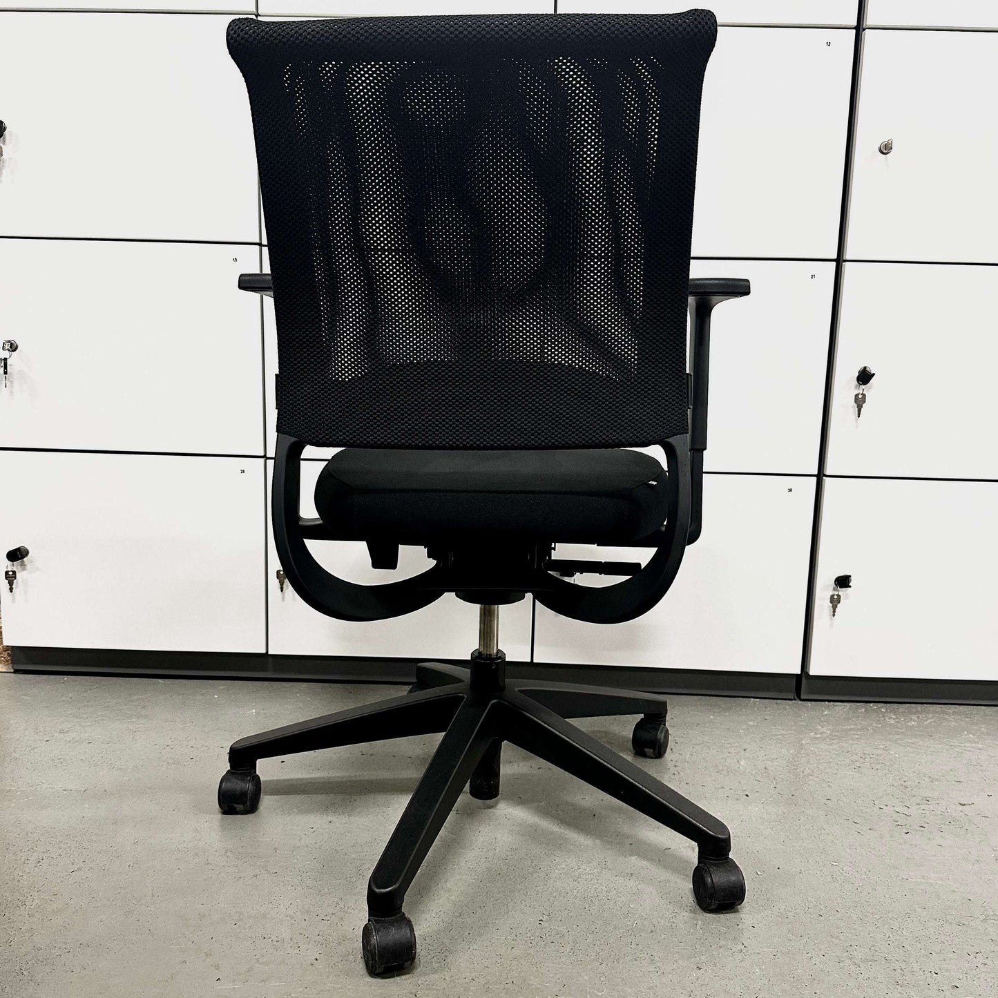 Black Sedus Netwin office chair with mesh backrest, adjustable armrests, lumbar support, black base, and caster wheels.