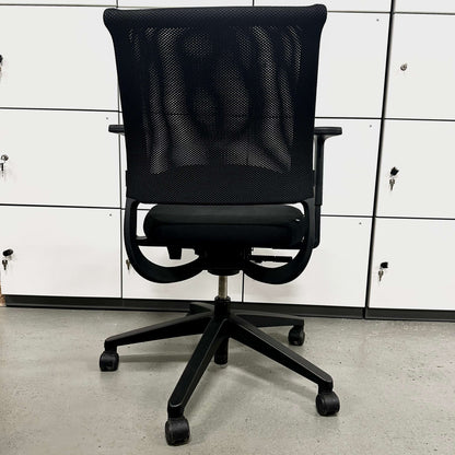 Black Sedus Netwin office chair with mesh backrest, adjustable armrests, lumbar support, black base, and caster wheels.