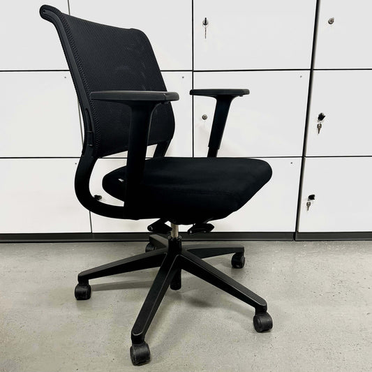 Black Sedus Netwin office chair with mesh backrest, adjustable armrests, lumbar support, height adjustment, black base, and caster wheels