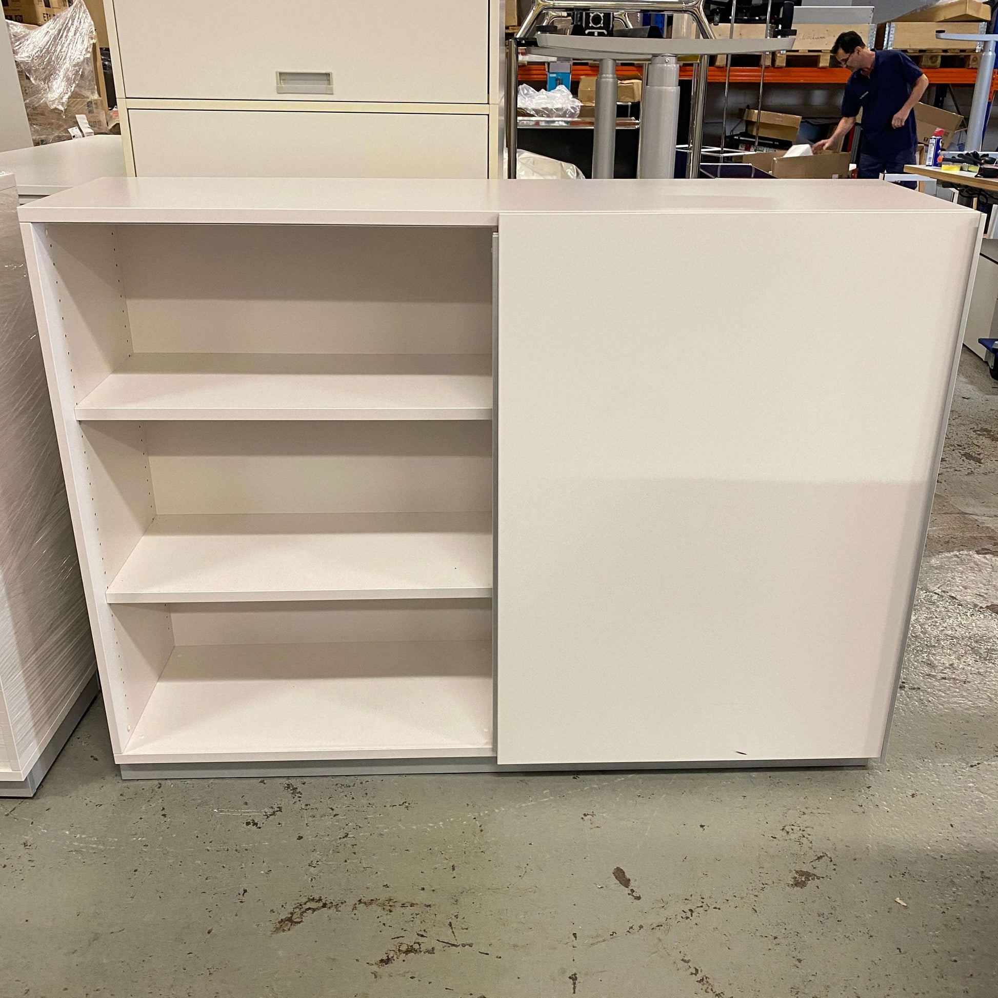 White sideboard 120cm with three open shelves and one closed cabinet door in a workshop setting