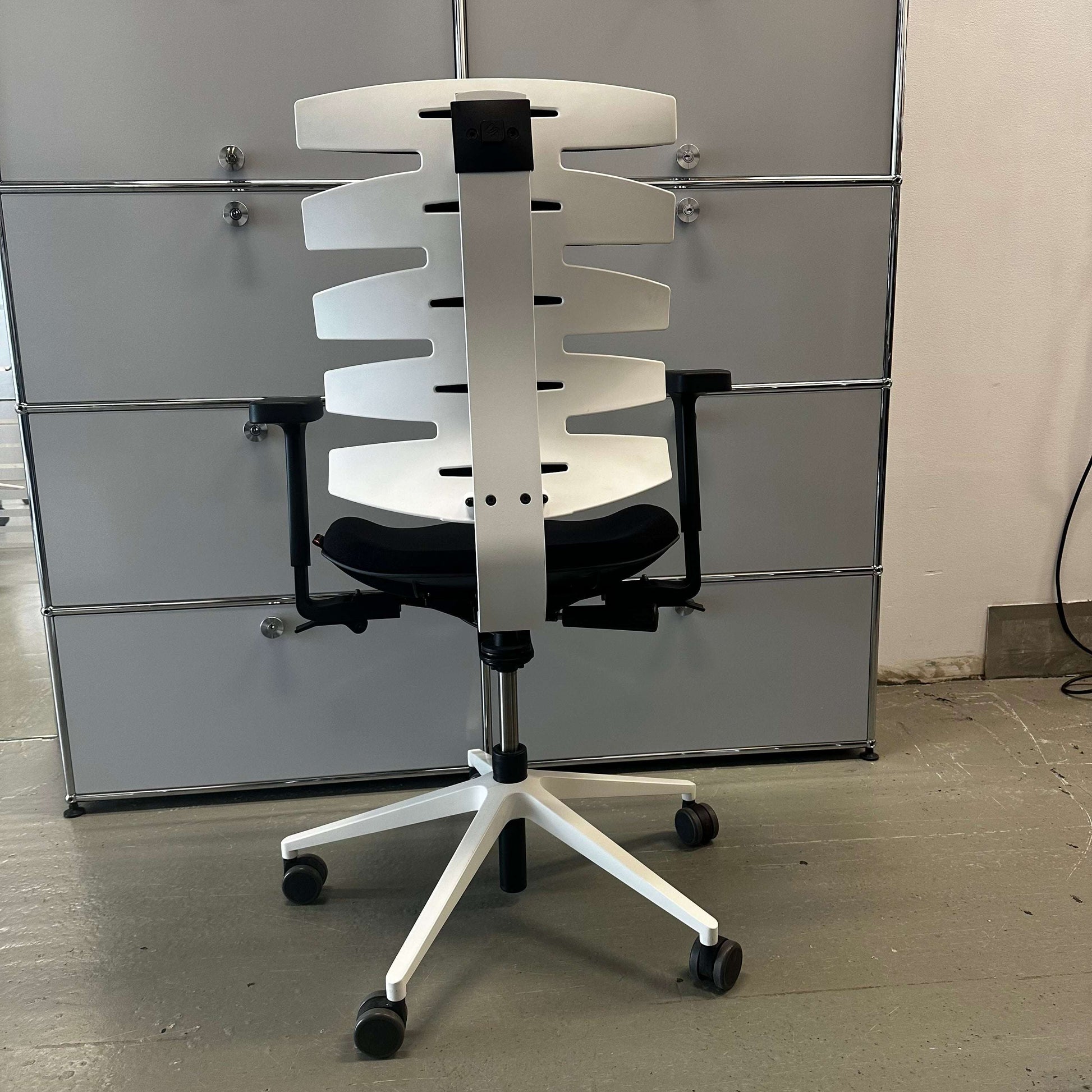 Sitag Wave ergonomic office chair with black upholstery, white frame, adjustable height, 3D armrests with soft pads, and adjustable backrest angle.