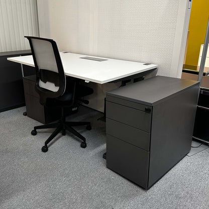 Steelcase Anstellcontainer anthracite wood mobile pedestal with three drawers next to office desk and black mesh chair