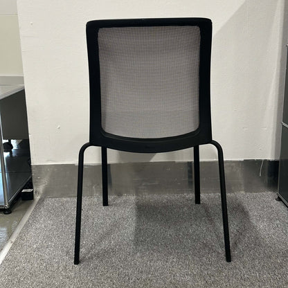 Black Steelcase Eastside Stapelstuhl with mesh backrest and four legs on carpeted floor