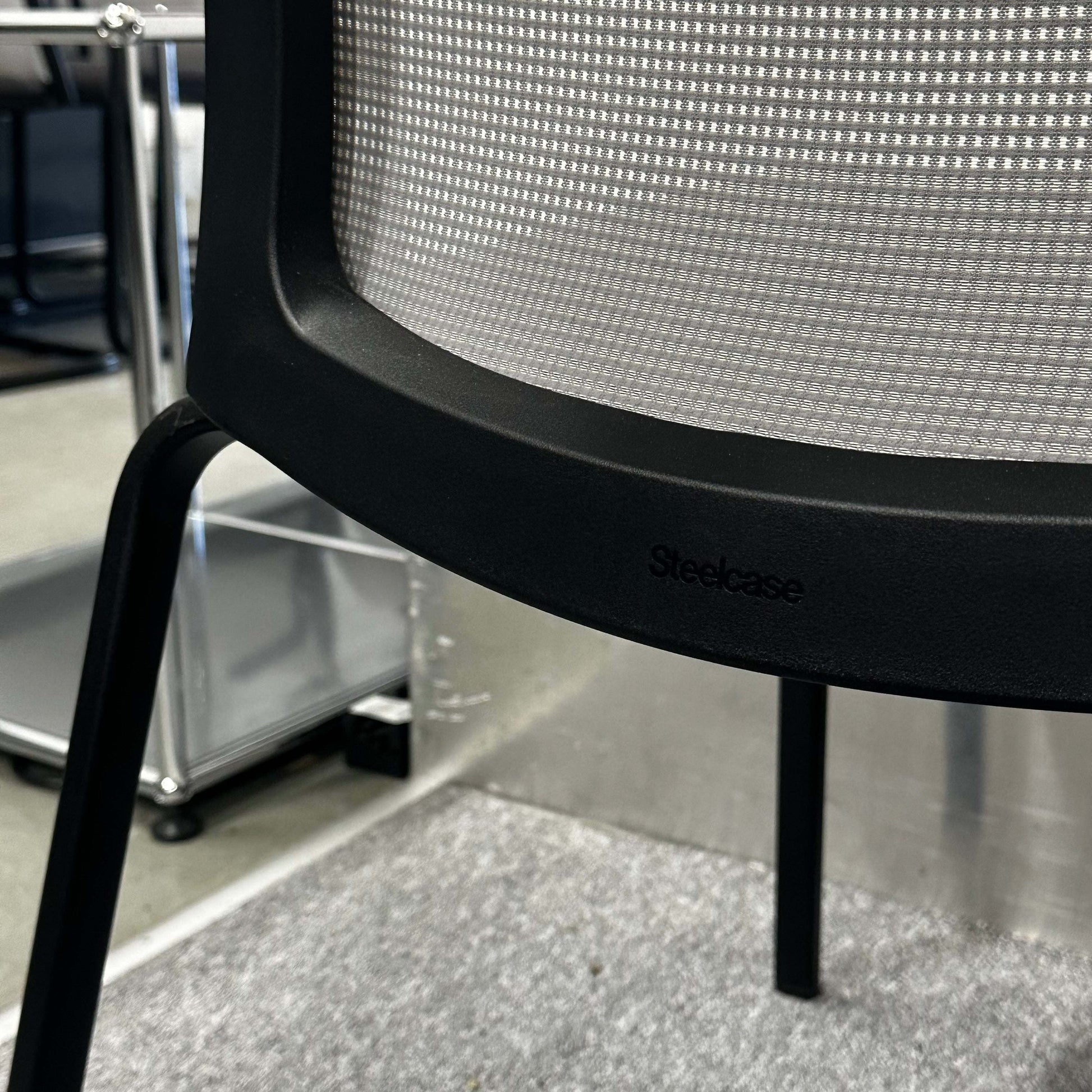 Steelcase Eastside Stapelstuhl modern stackable chair with mesh back and black frame in office setting