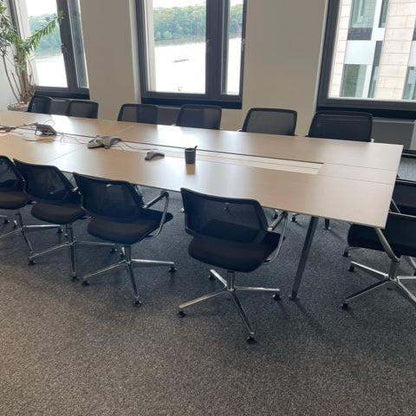 Großer Steelcase Konferenztisch 480x140 cm braun mit Kabeldurchlass und schwarzen Bürostühlen in modernem Besprechungsraum