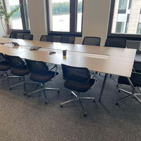 Großer Steelcase Konferenztisch 480x140 cm braun mit Kabeldurchlass und schwarzen Bürostühlen in modernem Besprechungsraum