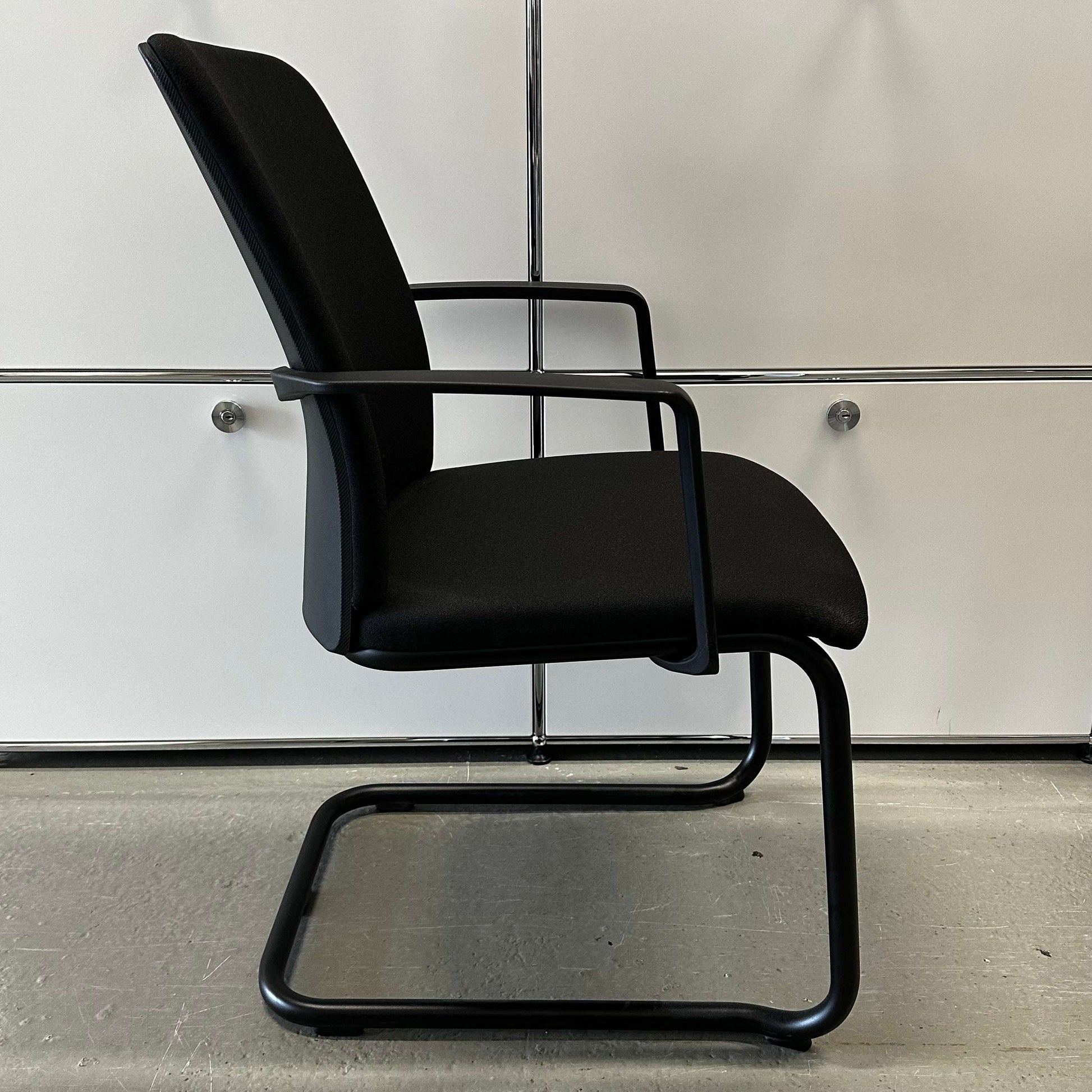 Steelcase Northside black padded meeting chair with sleek black frame, stackable design for office use