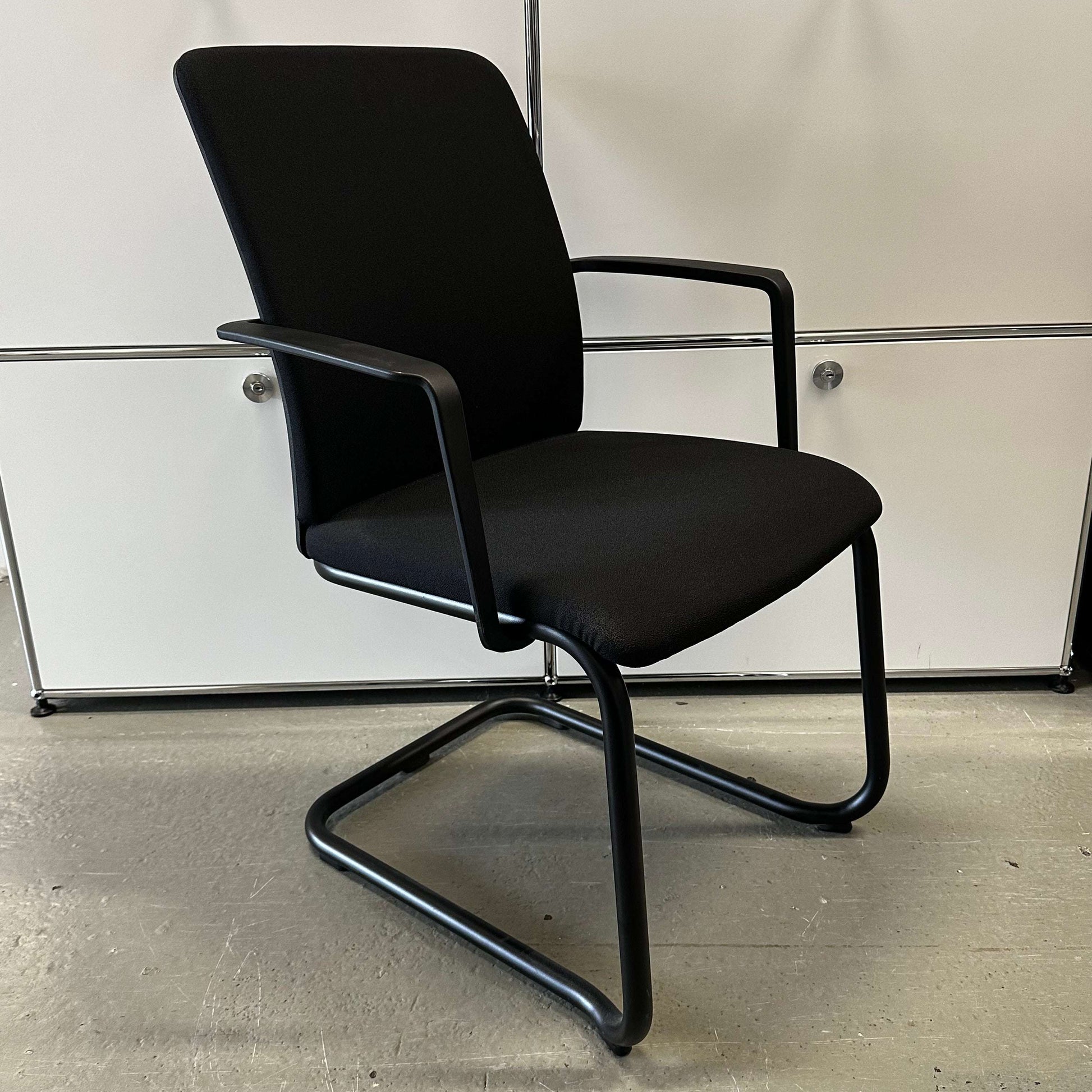 Steelcase Northside black padded meeting chair with black frame and armrests, stackable design for office use