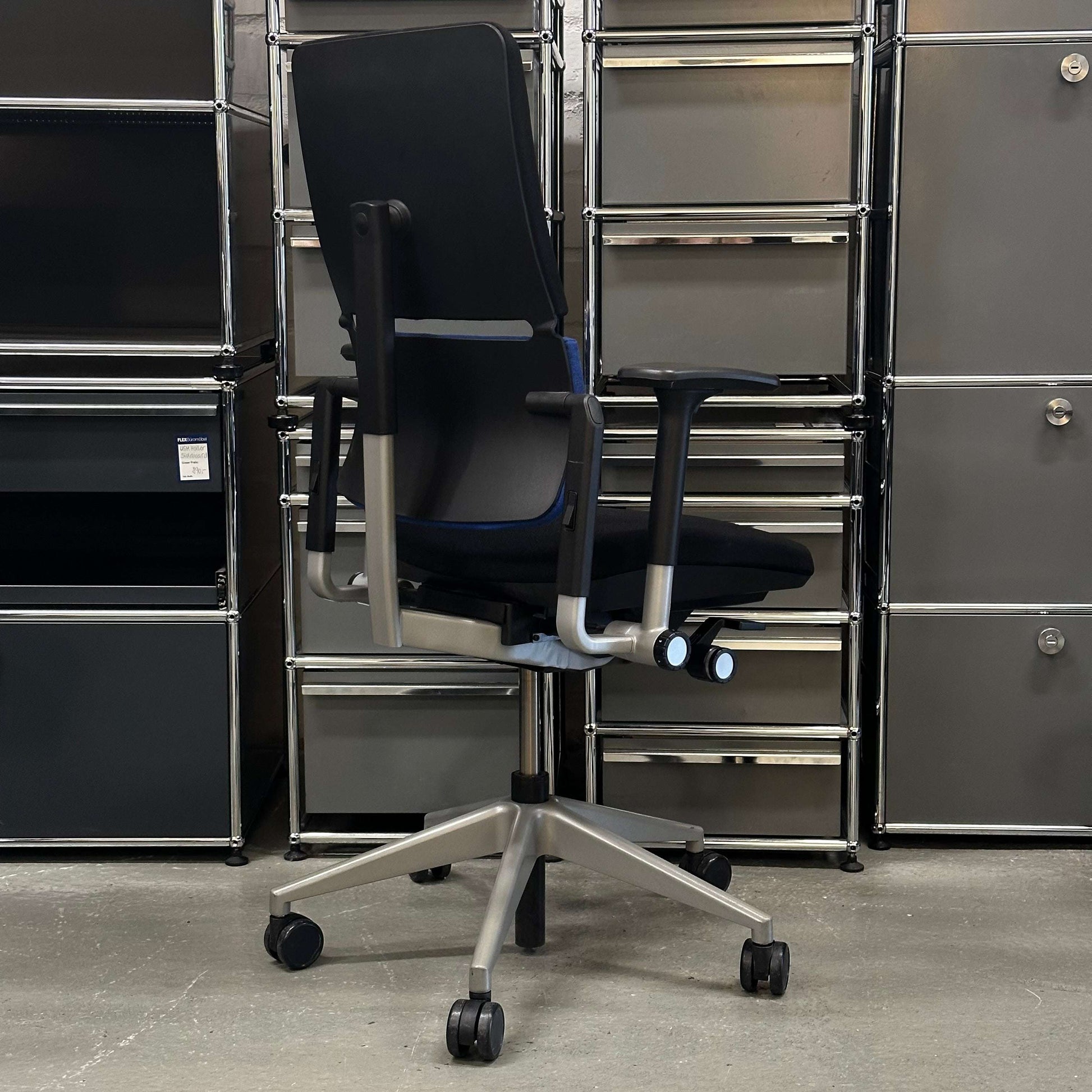 Steelcase Please ergonomic black office chair with adjustable armrests and silver base on caster wheels