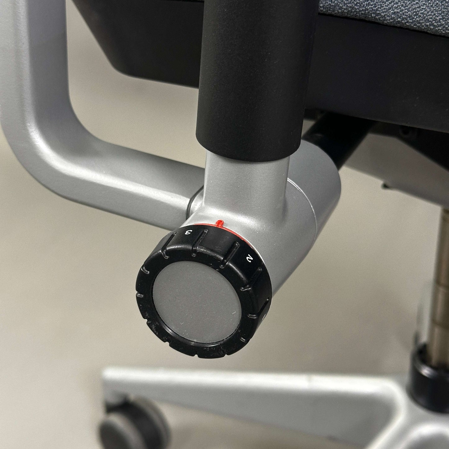 Detailaufnahme des Verstellknopfs am silber lackierten Metallgestell des ergonomischen Steelcase Please Bürostuhls in Grau