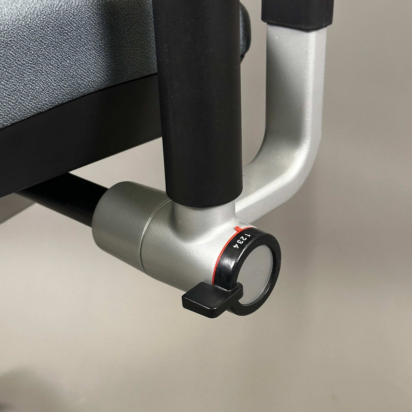 Nahaufnahme des verstellbaren Mechanismus des Steelcase Please Bürostuhls mit silbernem Metallgestell und grauem Bezug