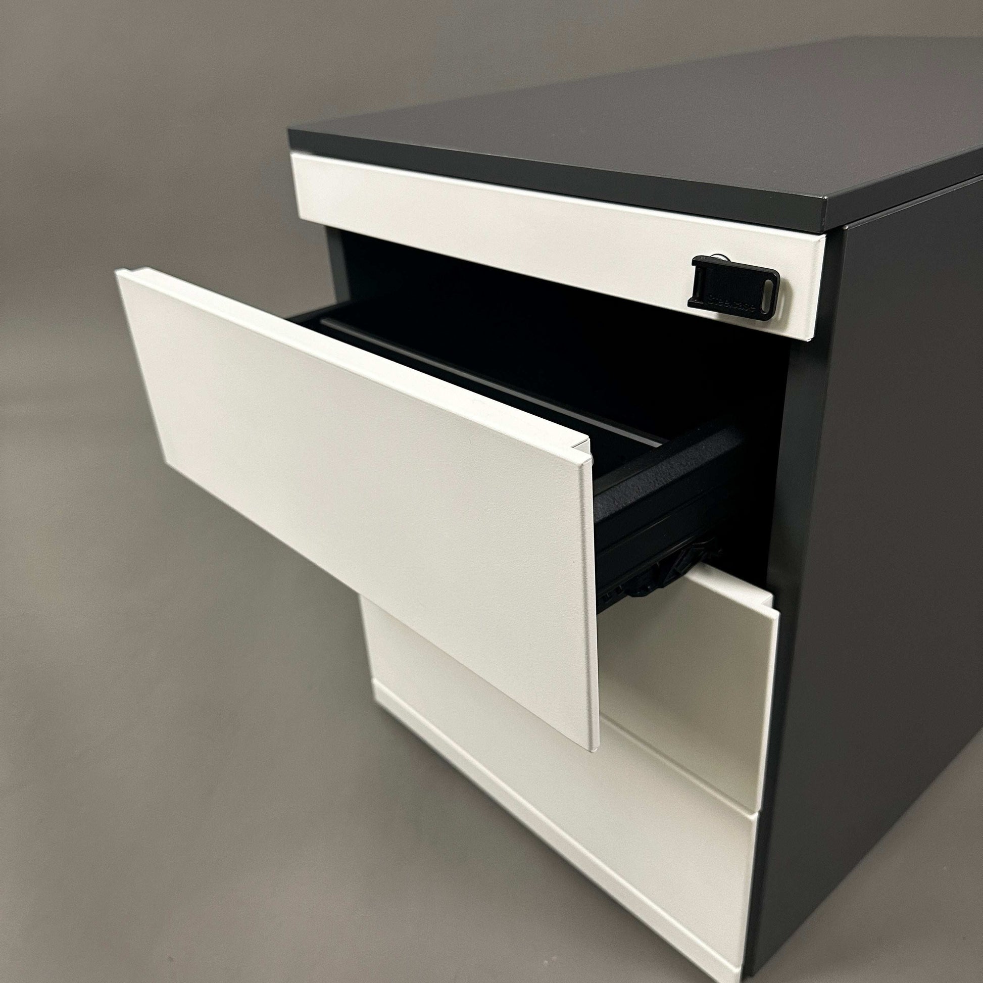 Steelcase Rollcontainer aus lackiertem Stahlblech in Anthrazit und Weiß mit vier abschließbaren Schubladen.
